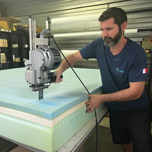 Technicien Ecomatelas assemblant les couches d'un matelas lors du reconditionnement